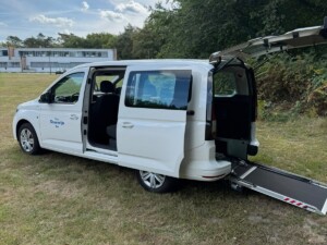 Rolstoeltaxi met geopende zijdeur en oprijplaat voor instappen